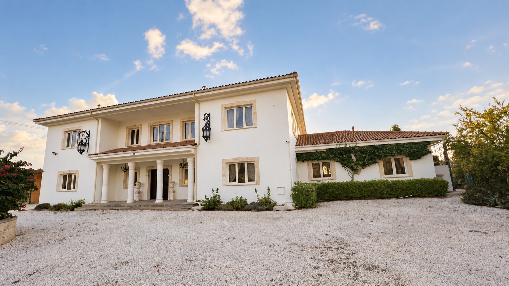 The real entrance to Villa Onassa, with its columned doorway and gravel courtyard
